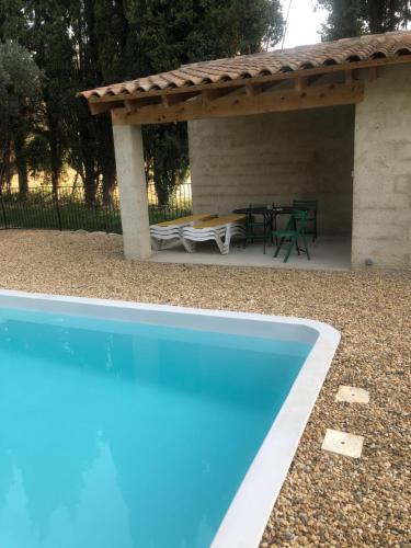 une piscine devant un patio avec une table dans l'établissement Mas de Papé, à Loriol-du-Comtat