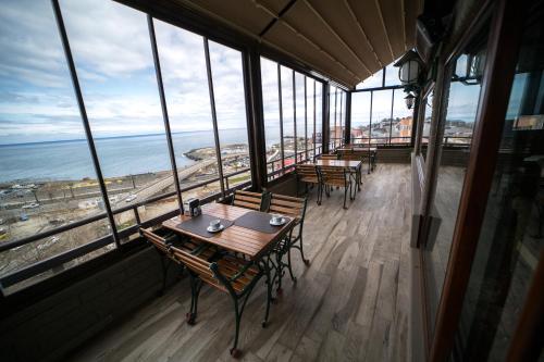 a restaurant with tables and chairs and a view of the ocean at Funda Hotel in Trabzon