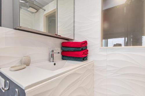 une salle de bain avec un lavabo, un miroir et des serviettes dans l'établissement Sweet dream Port nature, au Cap d'Agde