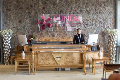 a man sitting at a desk with a laptop at Funda Hotel in Trabzon