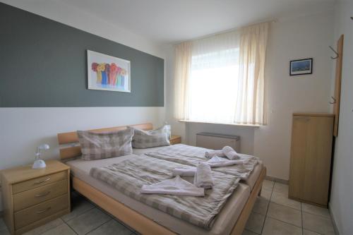 1 dormitorio con 1 cama con toallas en Deichstraße 15 W 14, en Norddeich