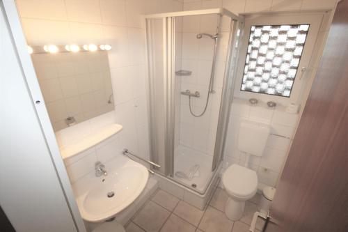 y baño con ducha, aseo y lavamanos. en Deichstraße 15 W 14, en Norddeich