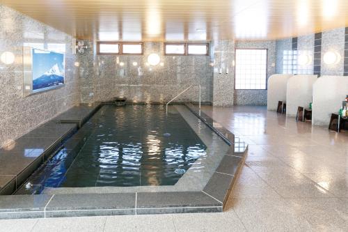 a pool of water in a room with chairs at Park Inn Takasaki in Takasaki