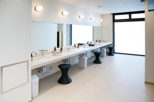 a bathroom with three sinks and a large mirror at Park Inn Takasaki in Takasaki
