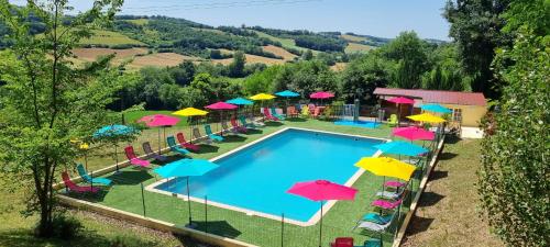 an overhead view of a swimming pool with colorful umbrellas at Camping Le Bourdieu in Durfort