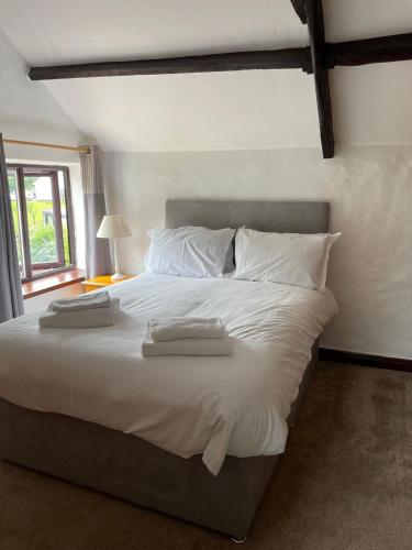 a bedroom with a large white bed with two towels on it at The White Horse Inn in Washford