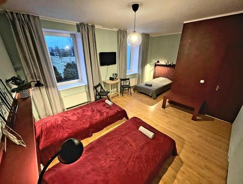 a living room with two beds and a television at Citrus SPA Hotel in Jēkabpils