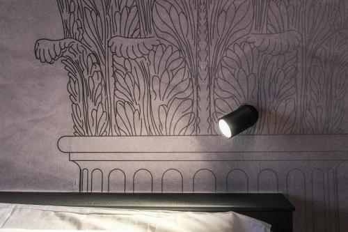 a bedroom with a wall with a design on it at Vicolo Malavolta 7 Rooms and Suites in Pedaso