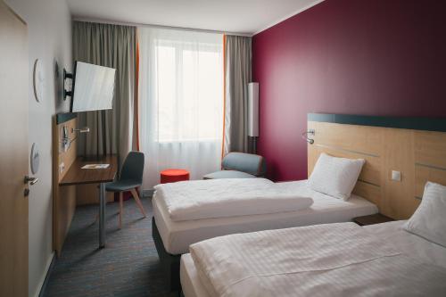 a hotel room with a bed and a desk at Vienna House Easy by Wyndham Bratislava in Bratislava