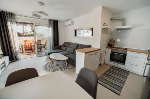een keuken en een woonkamer met een bank en een tafel bij Apartment Eveline in Petrcane