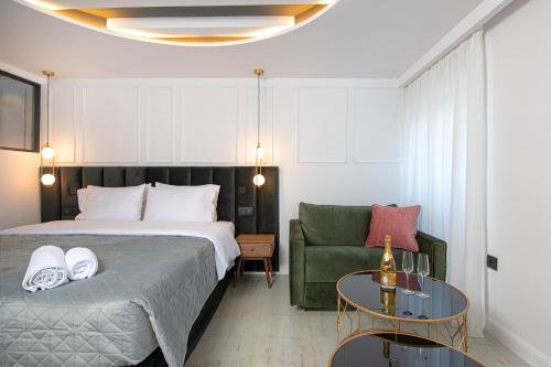Kantoni Luxury Suites في مدينة كورفو: غرفة نوم بسرير واريكة وطاولة