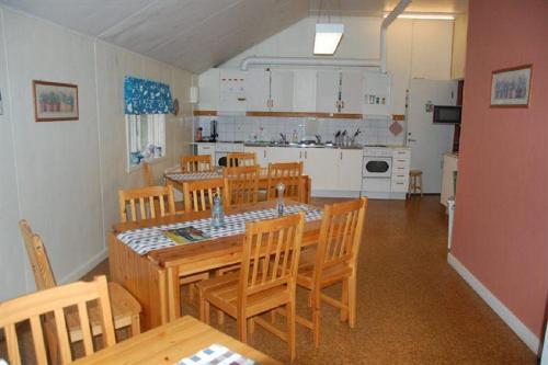 een eetkamer met een tafel en stoelen en een keuken bij Folsom in Årjäng