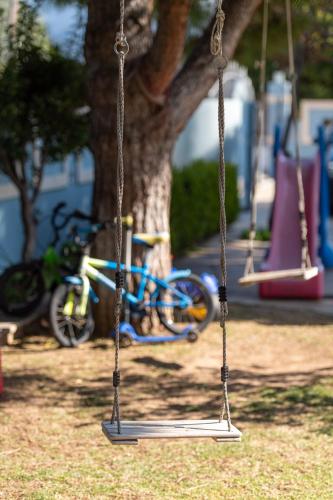 a swing in a park with a bike in the background at Aliki Guest House in Aígio