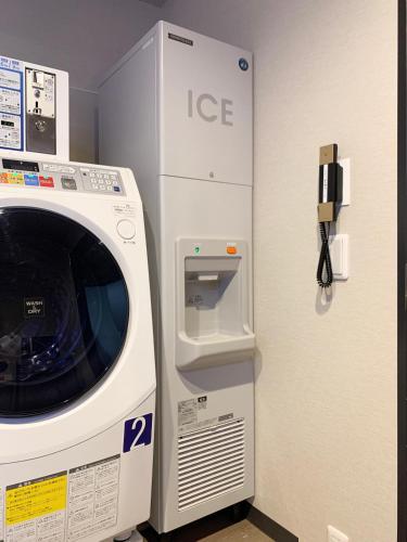 a washing machine is next to a wall at Hotel Torifito Kashiwanoha in Kashiwa