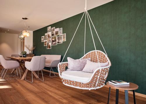 a wicker swing chair in a room with a table at WaldFunkeln LODGE in Hinterzarten