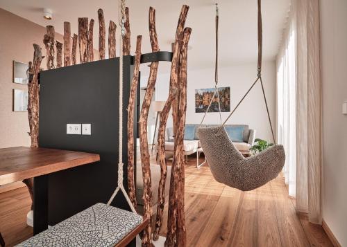 a living room with two hanging chairs and a table at WaldFunkeln LODGE in Hinterzarten