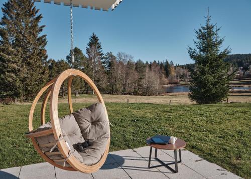 a hanging chair with a table in a park at WaldFunkeln LODGE in Hinterzarten