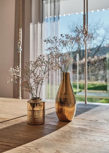 two vases with flowers in them sitting on a table at WaldFunkeln LODGE in Hinterzarten