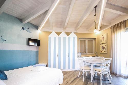 a bedroom with a table and chairs and a bed at Vicolo Malavolta 7 Rooms and Suites in Pedaso