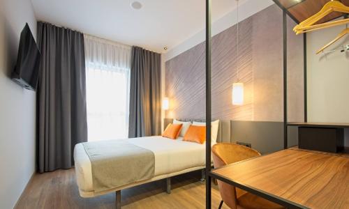 a hotel room with a bed and a table at DWO Yuste Alcalá in Madrid