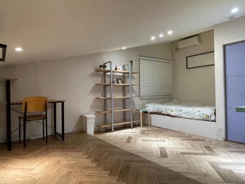 a room with a bed and a table and a shelf at SISnBRO Guesthouse in Seoul