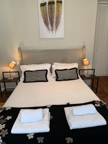 a bedroom with a large bed with two pillows at Maison Charles Maurice in Chalais