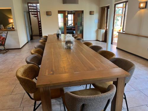 a long wooden table and chairs in a room at Hoeve de Knol in Holthees