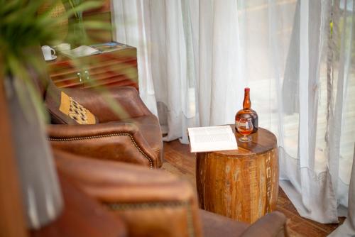 a bottle of wine sitting on a table next to a chair at Humura Resorts in Kampala