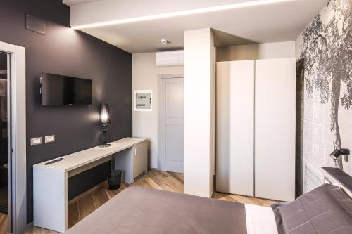 a bedroom with a desk and a tv on a wall at Vicolo Malavolta 7 Rooms and Suites in Pedaso