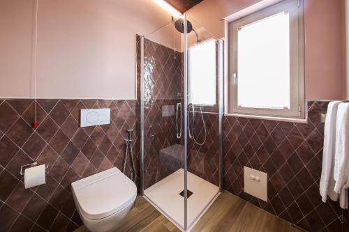 a bathroom with a toilet and a shower at Vicolo Malavolta 7 Rooms and Suites in Pedaso