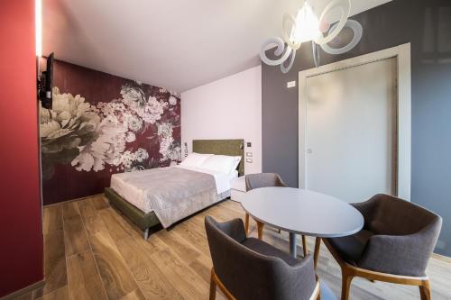 a bedroom with a bed and a table and chairs at Vicolo Malavolta 7 Rooms and Suites in Pedaso
