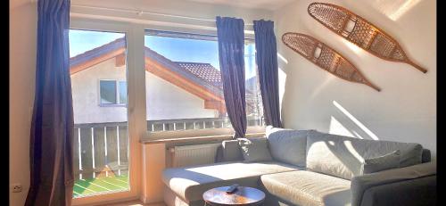 a living room with a couch and a large window at Ferienhaus Butterfly 2 in Garmisch-Partenkirchen