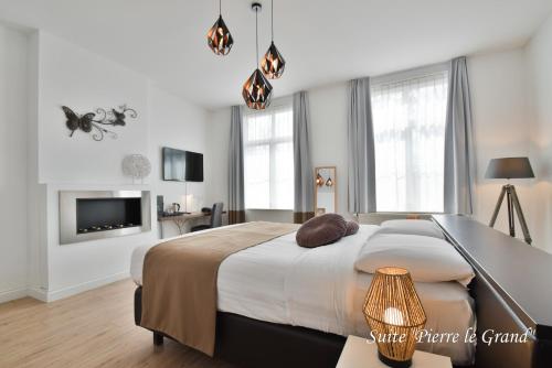 Un dormitorio con una cama grande y un televisor. en Hôtel l'Ecrin d'Ô, en Spa