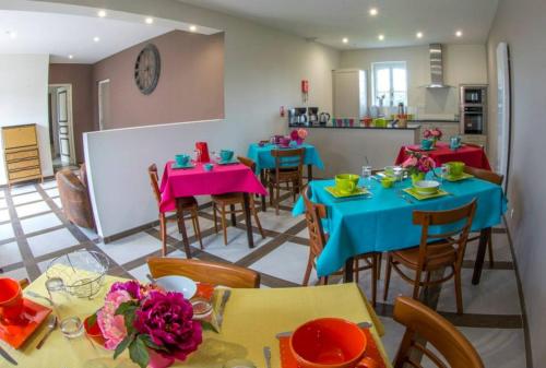 ein Esszimmer mit Tischen und Stühlen sowie eine Küche in der Unterkunft Le parc de Crécy in Crécy-Couvé