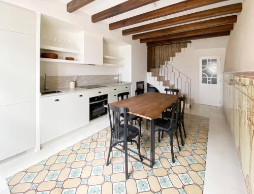 a kitchen with a wooden table and black chairs at Terra i Mar in Cabanes