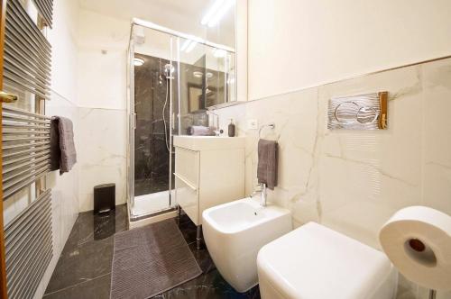 a white bathroom with a toilet and a sink at Calle dei Fabbri Apartment Marble in Venice