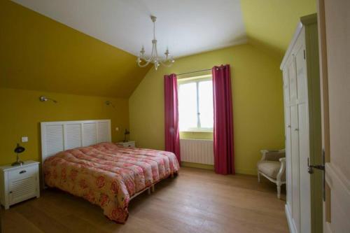 Dormitorio amarillo con cama y ventana en Le parc de Crécy, en Crécy-Couvé