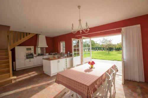 a kitchen with a table and a kitchen with red walls at Le parc de Crécy in Crécy-Couvé