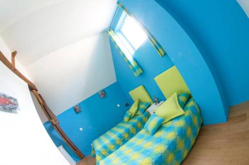 a room with a blue and yellow couch in a room at Le parc de Crécy in Crécy-Couvé