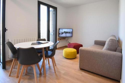 a living room with a table and chairs and a couch at APG Girona Carme 19 in Girona