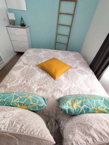 a bed with two pillows and a ladder at Appartement avec terrasse - M4 Lucie Aubrac in Bagneux