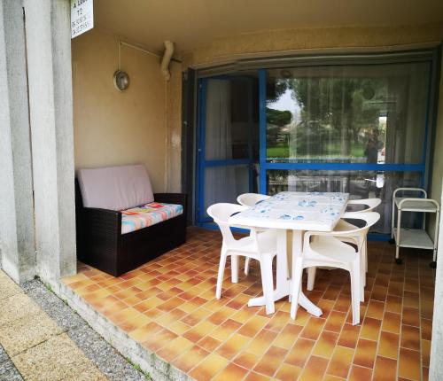 um pátio com uma mesa, cadeiras e um sofá em Charmant T2 en rez de chaussée em Balaruc-les-Bains