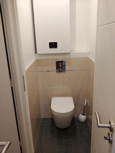 a bathroom with a toilet with a clock on the wall at Appartement avec terrasse - M4 Lucie Aubrac in Bagneux
