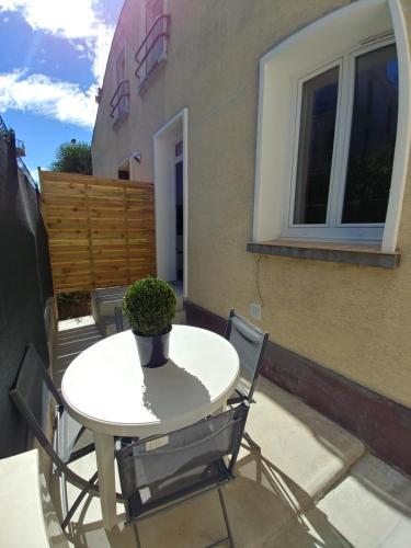uma pequena mesa branca e cadeiras num pátio em Appartement avec terrasse - M4 Lucie Aubrac em Bagneux