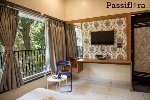 a room with a desk and a window at Passiflora Beach Resort Alibaug in Alibaug