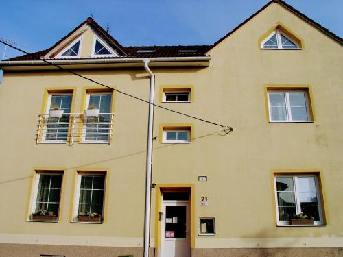 a yellow house with windows at Penzion pod Kostelíčkem in Třebíč