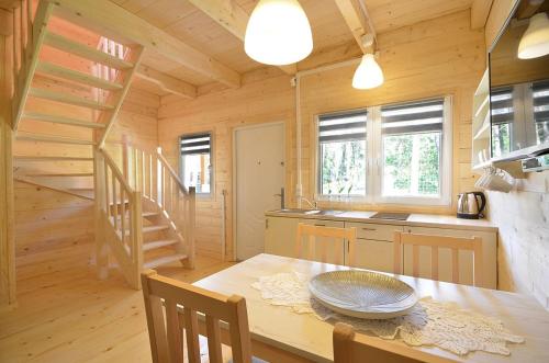 a kitchen and dining room with a table in a cabin at Morska Fala Domki in Pobierowo