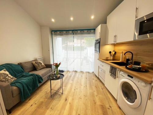 un petit salon avec un canapé et une cuisine dans l'établissement BalnéoPlage, à Jard-sur-Mer