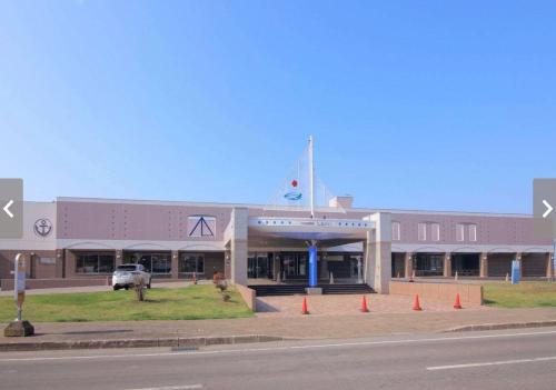 a building with a car parked in front of it at Spa SHIOSAI in Toyoura