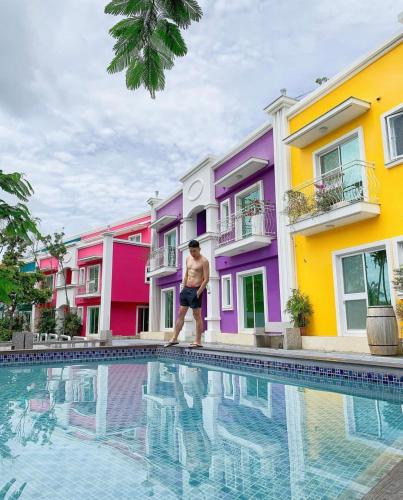 a man is standing next to a swimming pool at 沉靛旅宿 La Casa Indaco 墾丁夢幻島Villa in Sigou